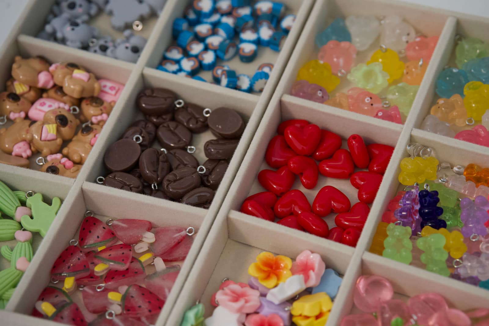 Sortierfach voller bunter Resin-Charms: Koalas, Herzen, Gummibärchen und Früchte
